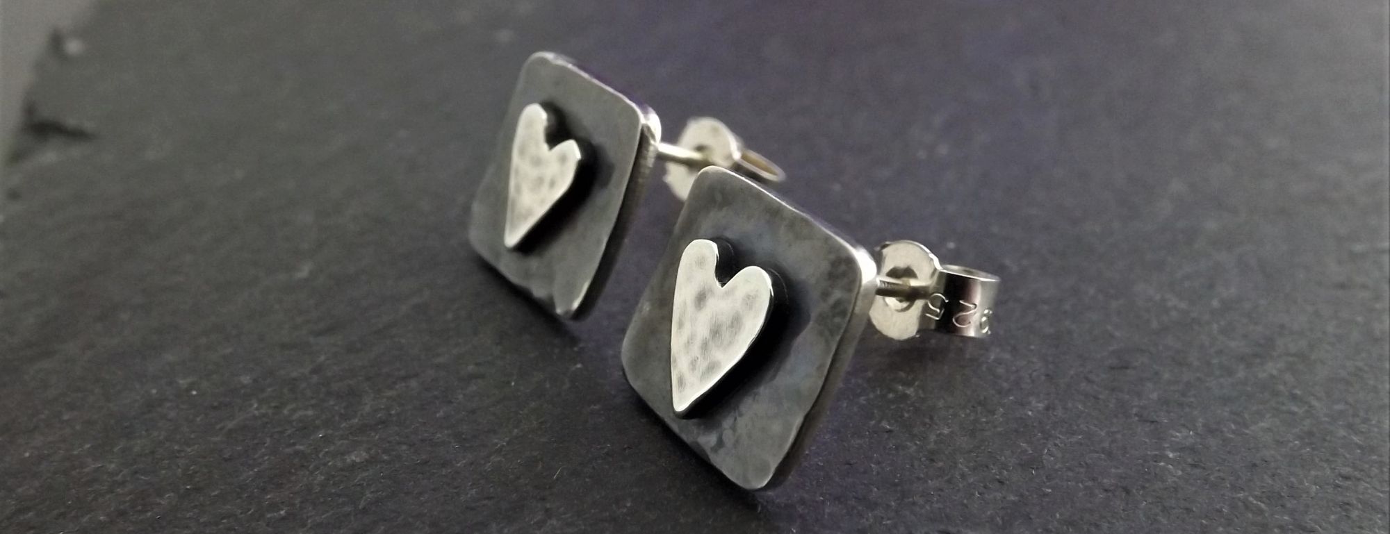 A pair of heart designed silver earrings